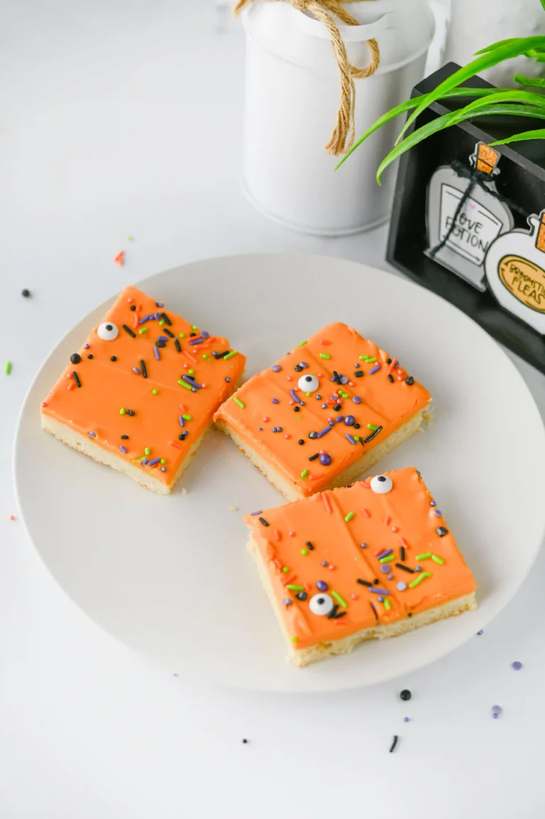 Halloween Sugar Cookie Bars with orange icing and halloween sprinkles