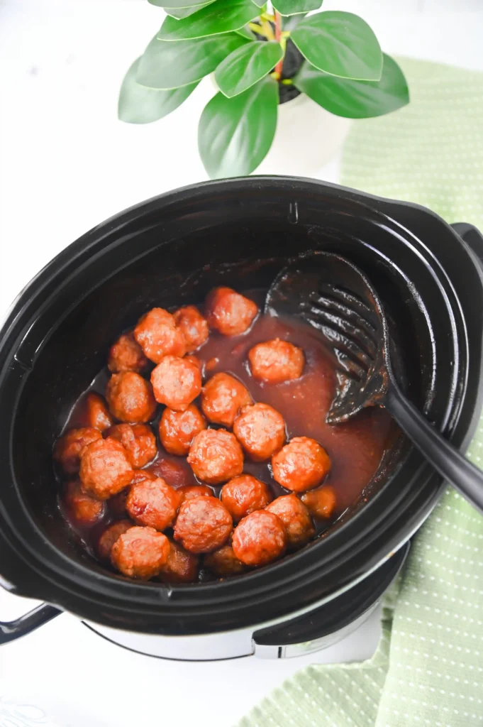 cranberry meatballs in a crockpot with a spoon