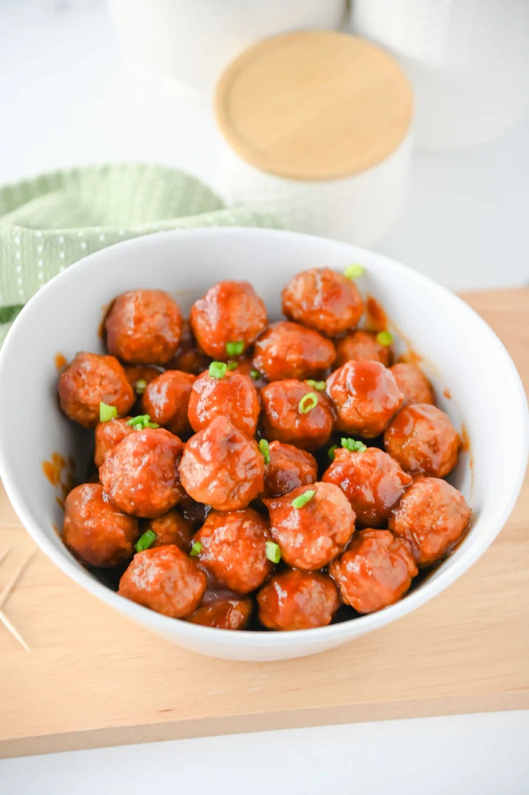 Cranberry Meatballs in a white bowl on a wooden board