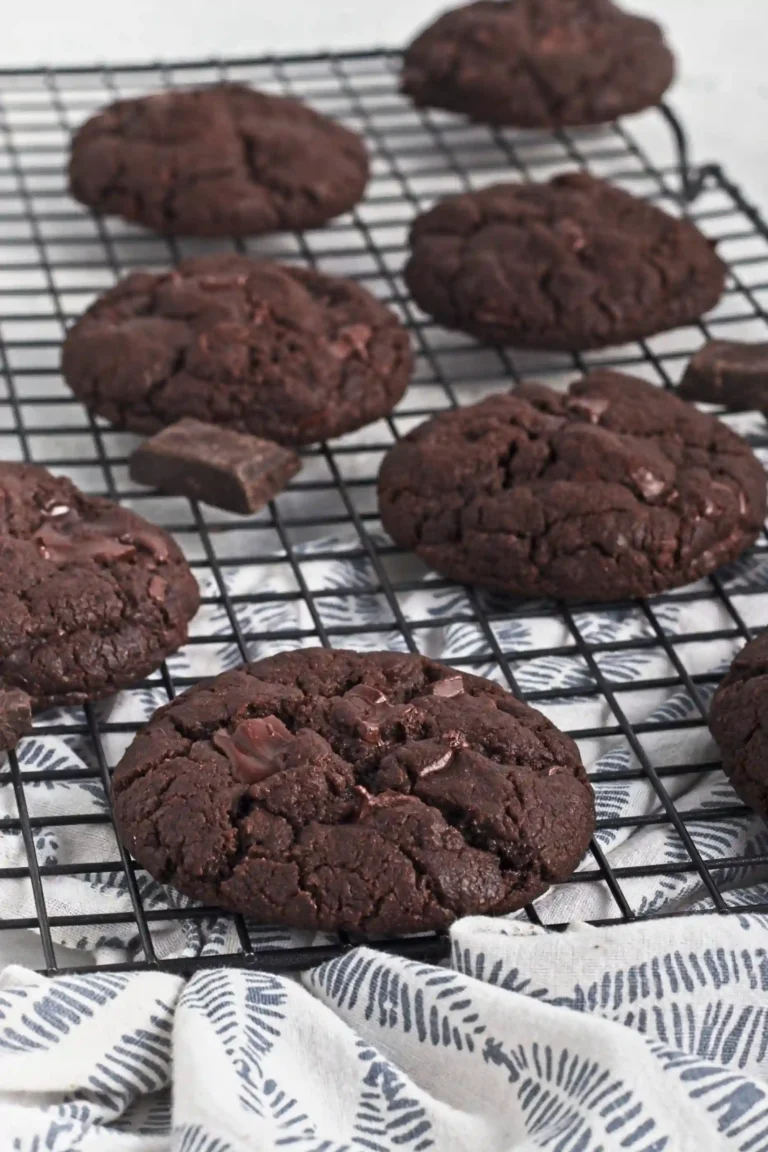 Double Chocolate Cookies with chocolate chips on a black cooling rack