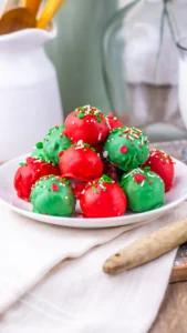 Christmas butterfinger balls coated in red and green chocolate with Christmas-themed sprinkles on top