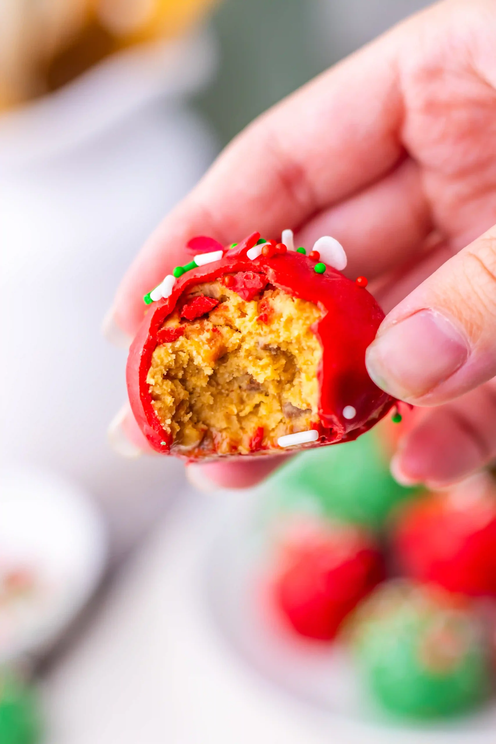 Christmas butterfinger balls coated in red and green chocolate with Christmas-themed sprinkles on top
