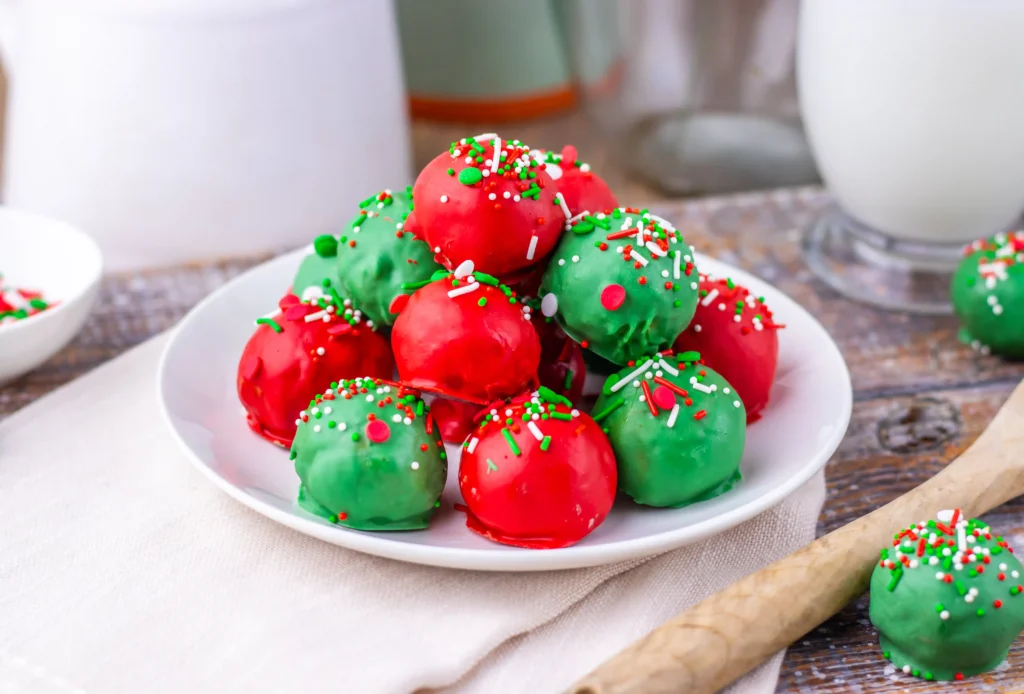 Christmas butterfinger balls coated in red and green chocolate with Christmas-themed sprinkles on top