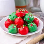 Christmas butterfinger balls coated in red and green chocolate with Christmas-themed sprinkles on top