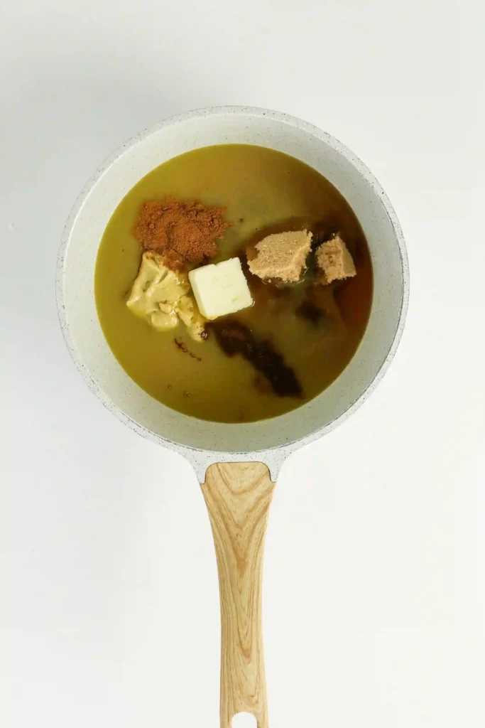 honey, brown sugar, orange juice, Dijon mustard, butter, cinnamon, and cloves in a bowl