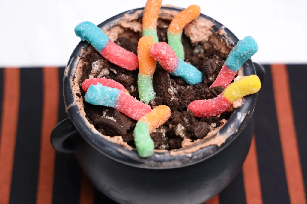 Halloween Dirt Cups in a cauldron and toped with gummy worms