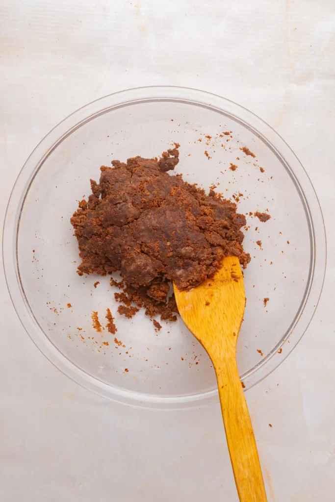 chocolate cake and cream cheese mixture in a bowl with a yellow spatula