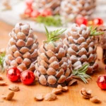 pinecone truffles with powdered sugar on top and sprigs of herbs and ornaments around