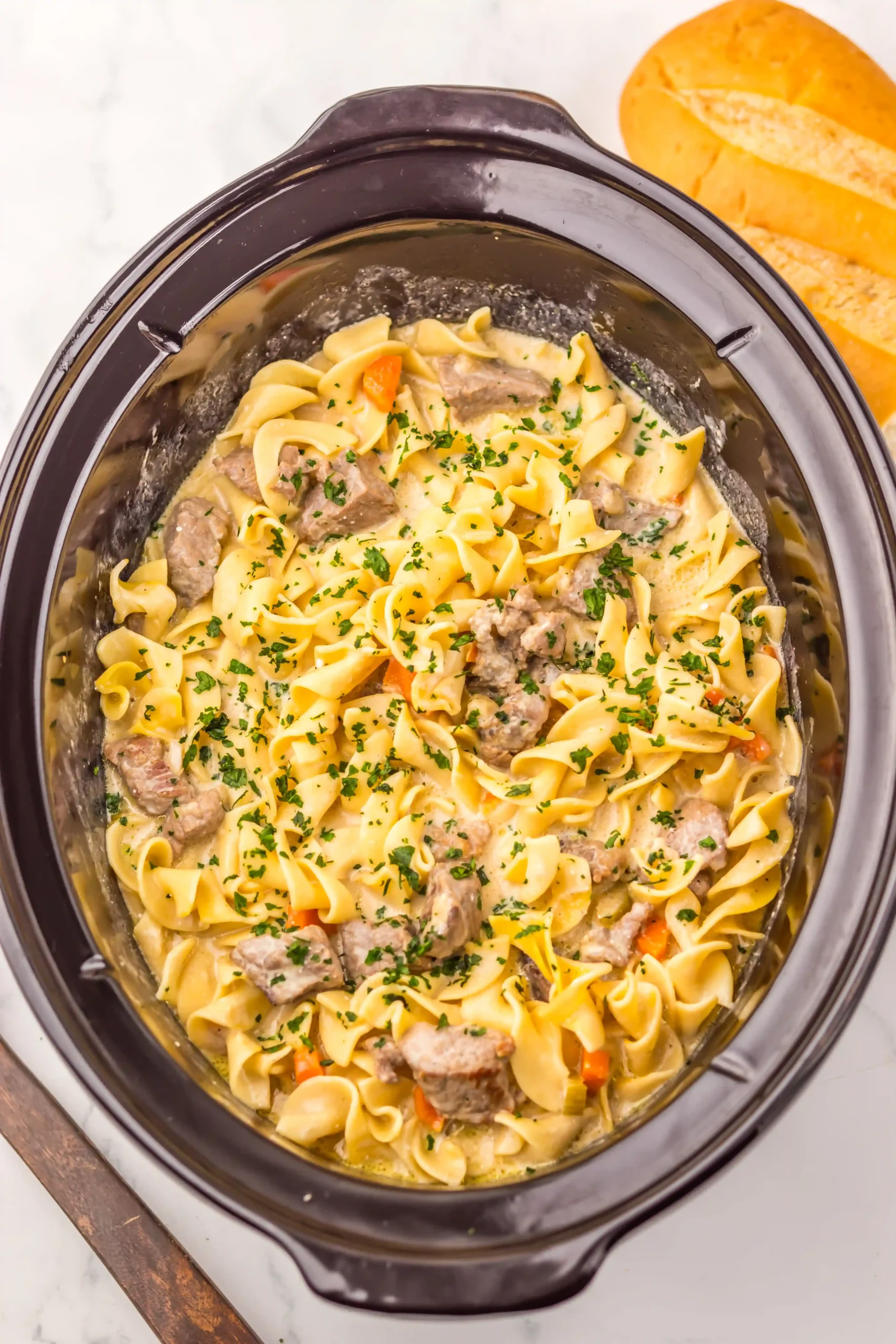a crockpot filled with beef and noodle soup