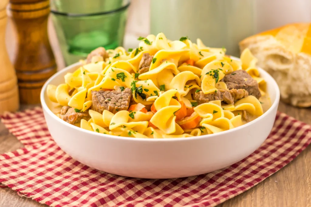 slow cooker creamy beef noodle soup in. a white bowl