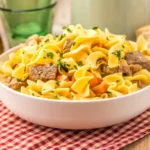 slow cooker creamy beef noodle soup in. a white bowl