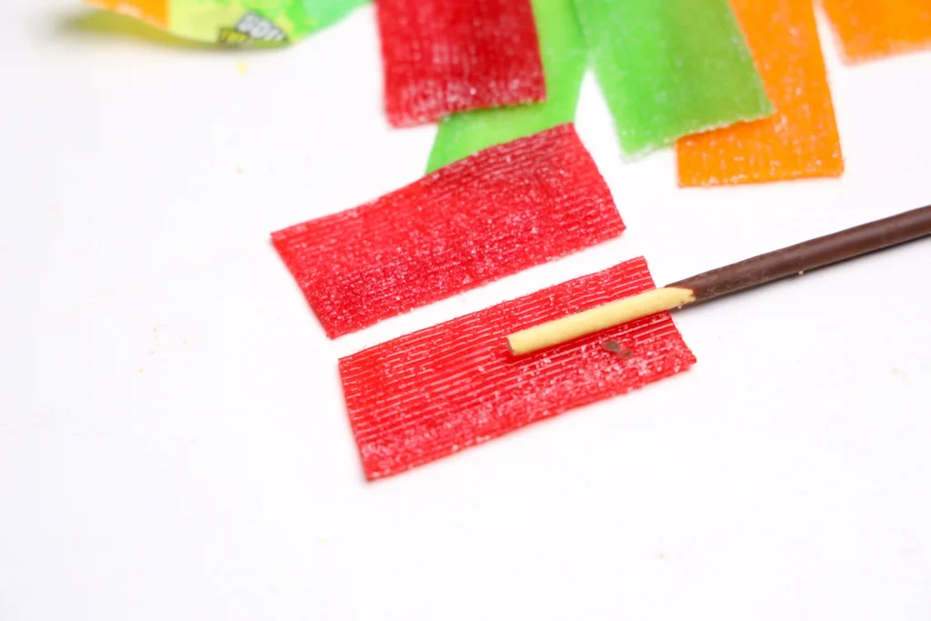 a sour patch strip with a pocky stick on top