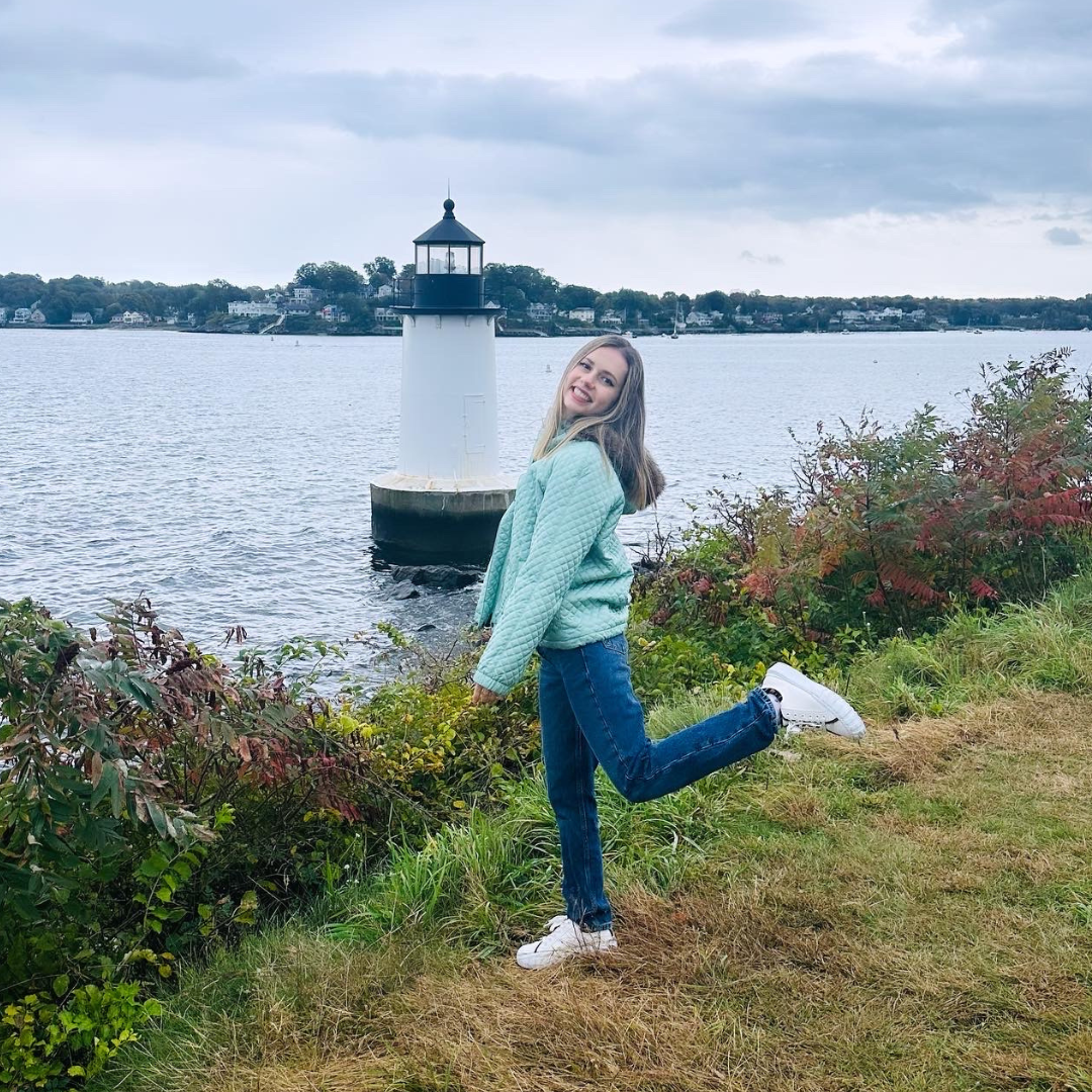 a photo of a girl near a lighthouse