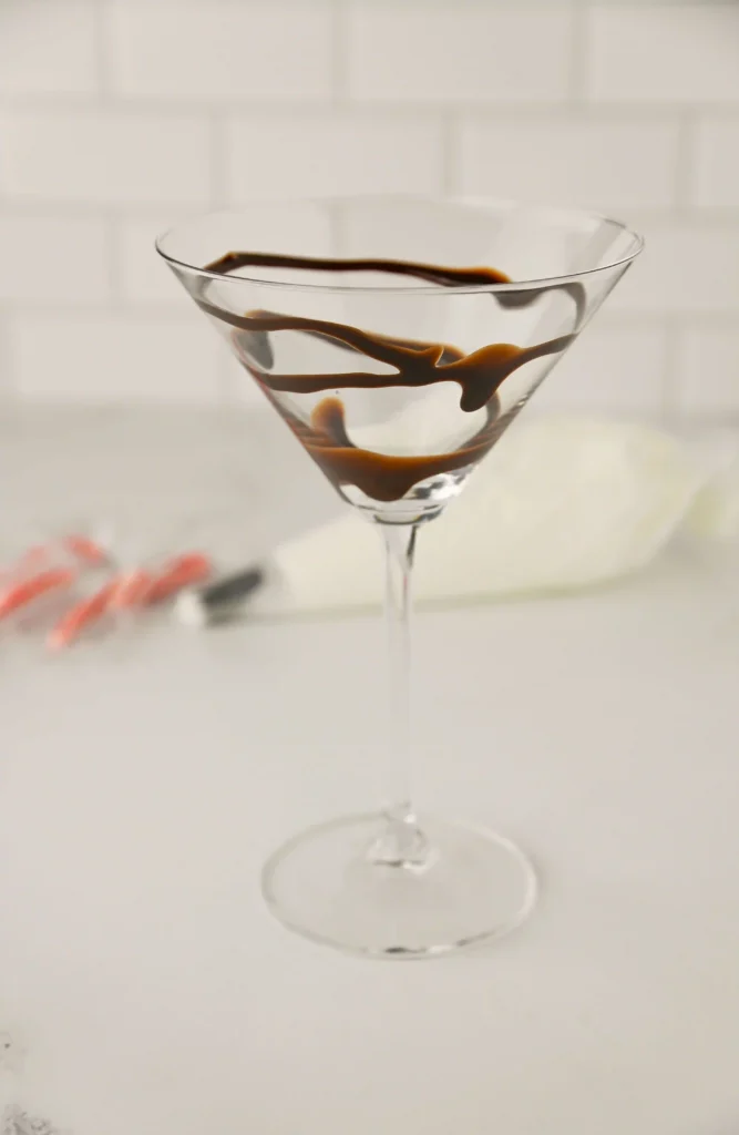a martini glass with chocolate drizzled inside