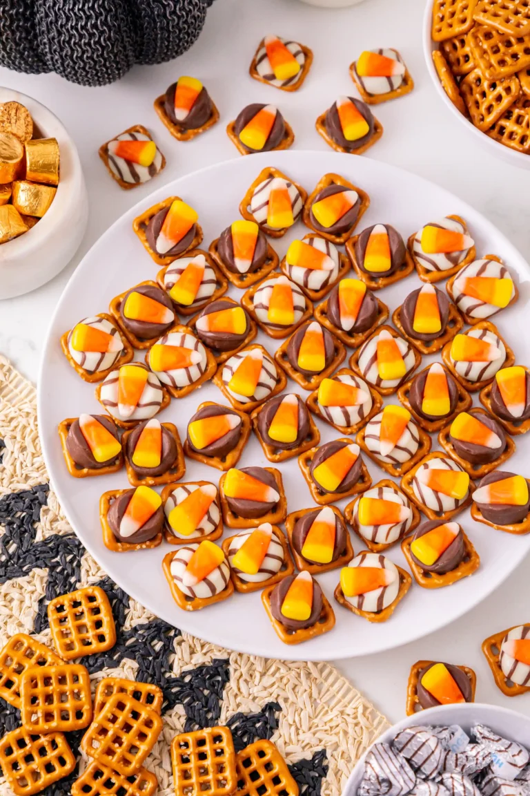 pretzels with chocolate and candy corn on top on a white plate