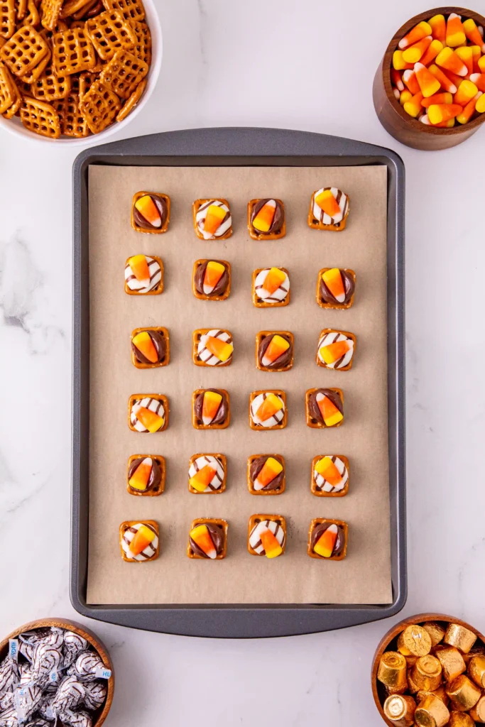 candy corn pretzel bites on a baking sheet with parchment paper