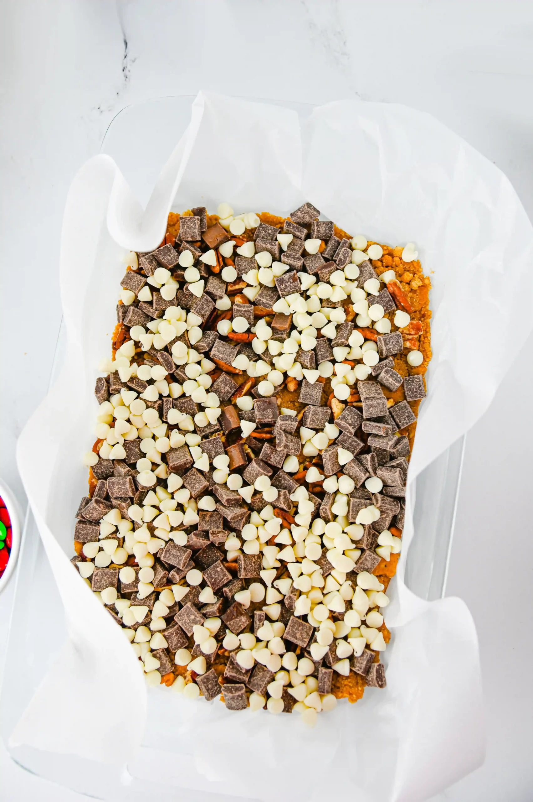 a graham cracker crust with pecans and chocolate chips on top
