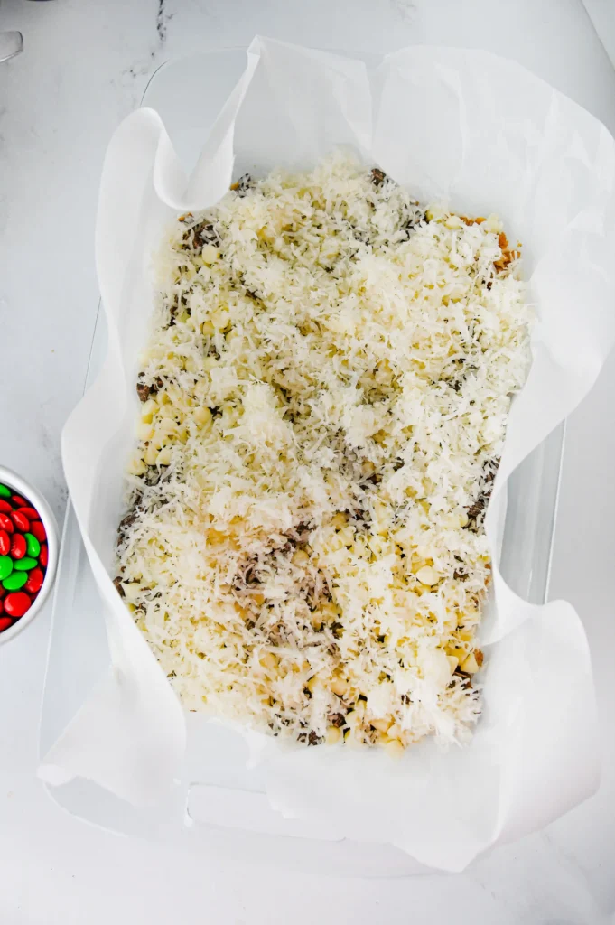 a graham cracker crust with pecans, chocolate chips, and coconut on top