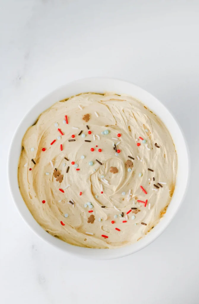 a gingerbread dip in a glass bowl with gingerbread sprinkles