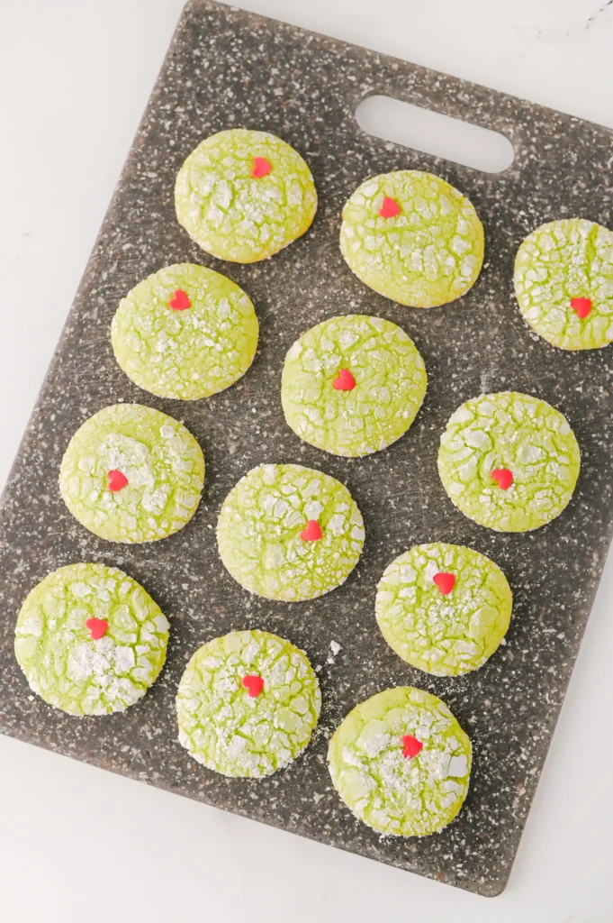 green crinkle cookies with a red heart sprinkle