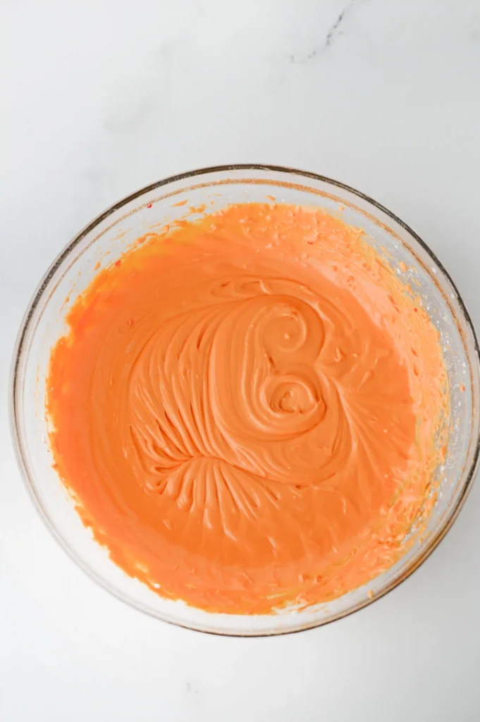 orange icing in a glass bowl