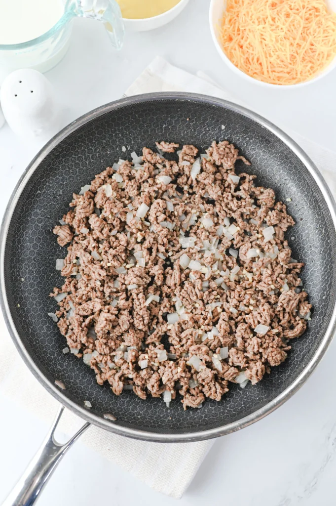 beef and onions cooking in a pan