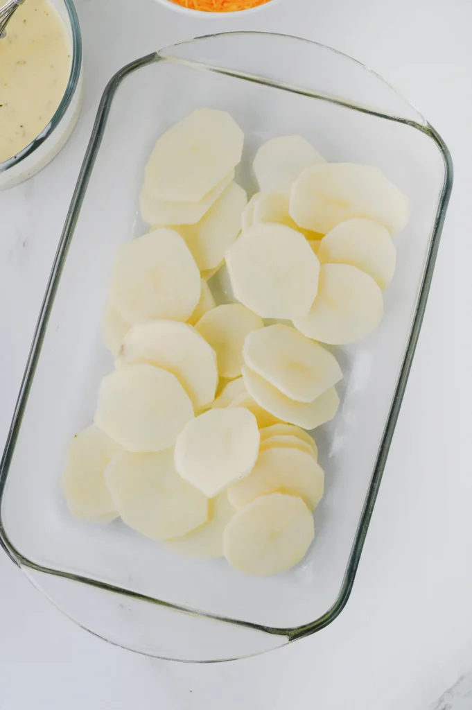 a glass pan with sliced potatoes