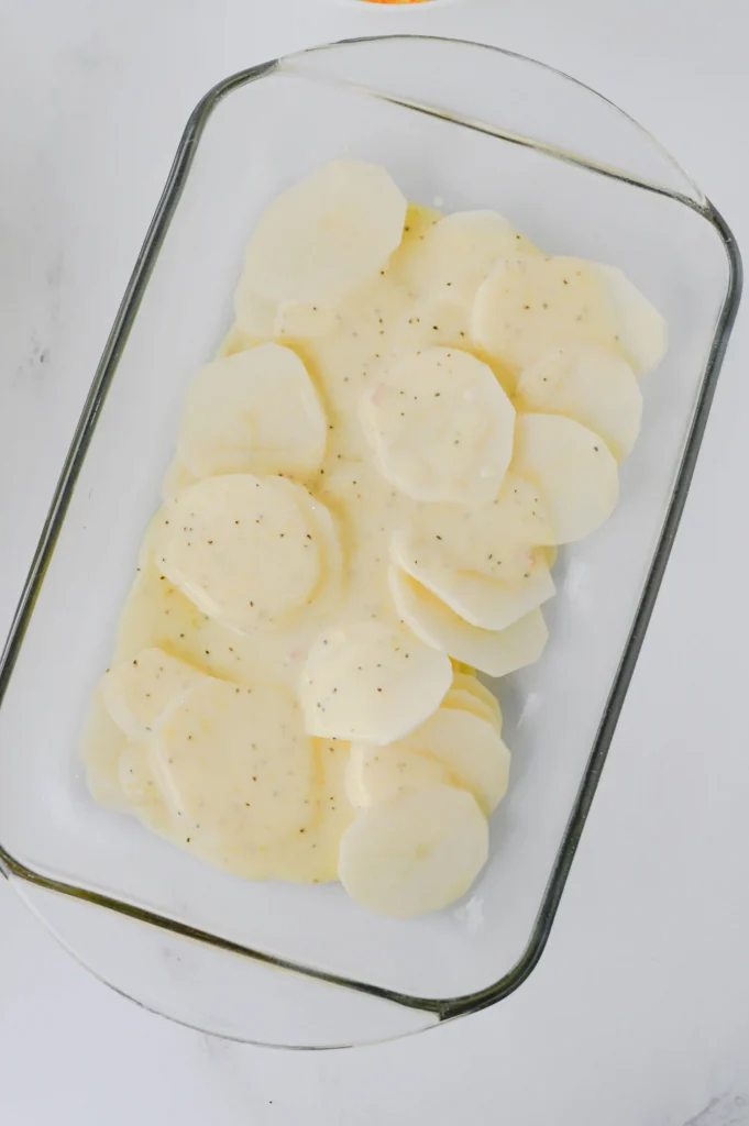 potatoes in a glass pan with cream of chicken soup