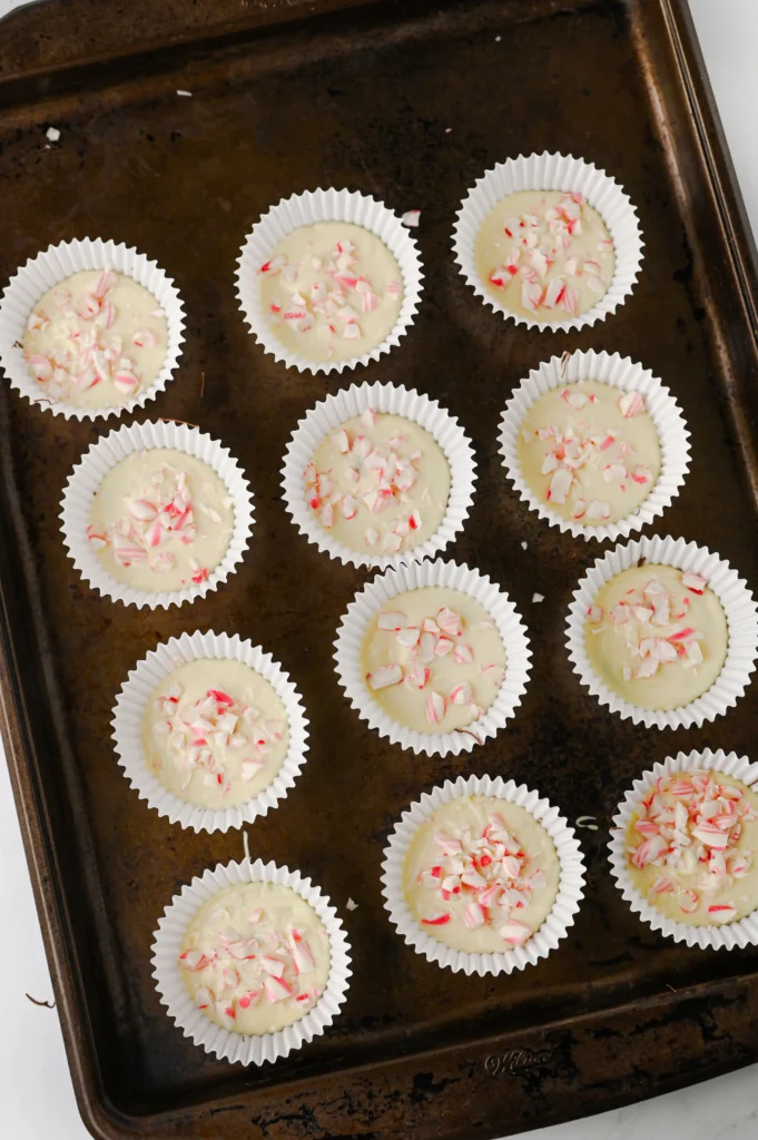 peppermint bark cups with chocolate and crushed peppermint on top on a baking sheet