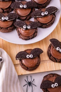 reese's and oreos on top of a chocolate cookie to look like a bat