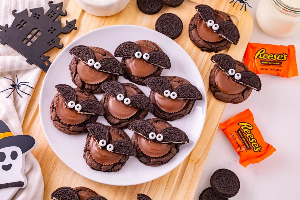 reese's and oreos on top of a chocolate cookie to look like a bat
