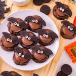 reese's and oreos on top of a chocolate cookie to look like a bat