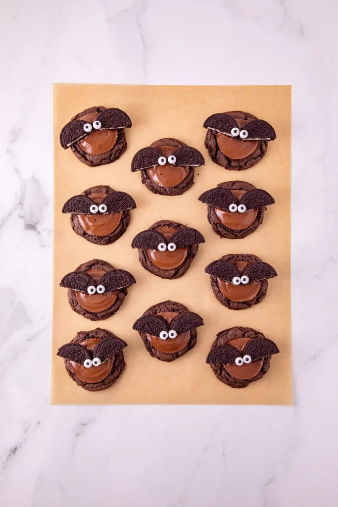 reese's and oreos on top of a chocolate cookie to look like a bat