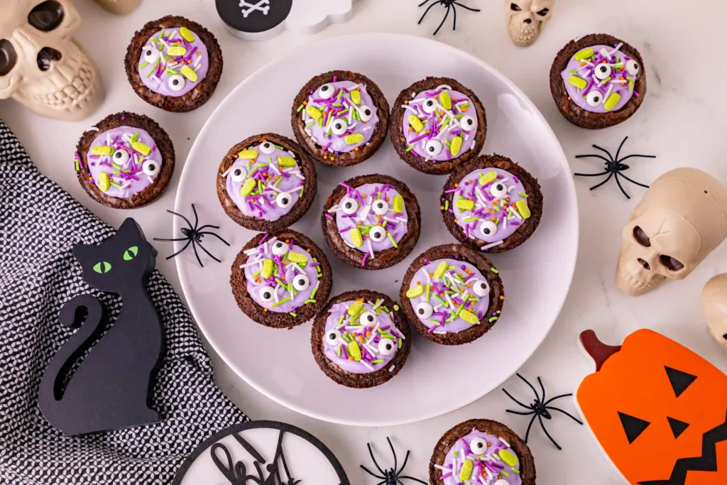 Witch Cauldron Brownies of brownies with purple icing and halloween sprinkles