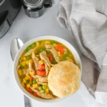 Crock Pot Chicken Pot Pie soup in a bowl with a biscuit