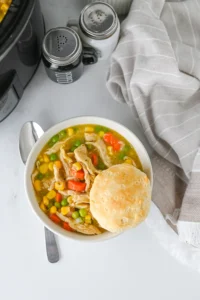 Crock Pot Chicken Pot Pie soup in a bowl with a biscuit