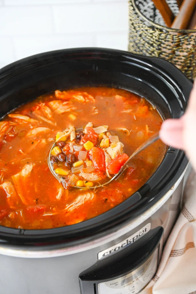 a crockpot of enchilada soup with a label scooping some out