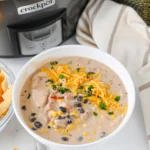 Cream Cheese Chicken Chili with cheese on top in a white bowl