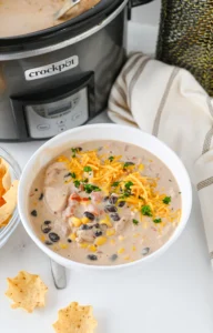 Cream Cheese Chicken Chili with cheese on top in a white bowl