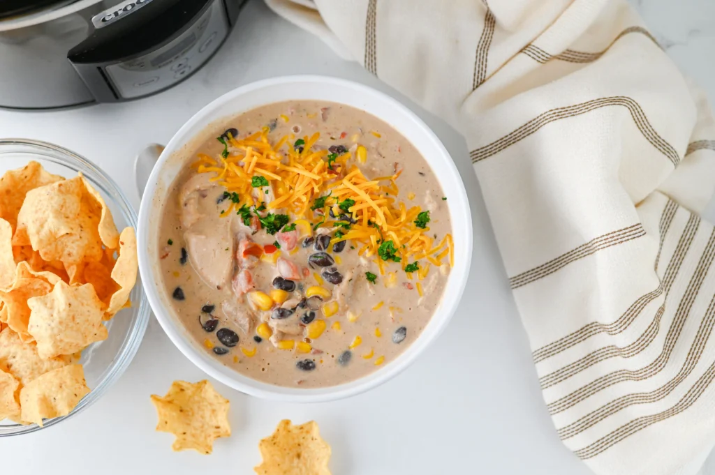 Cream Cheese Chicken Chili with cheese on top in a white bowl