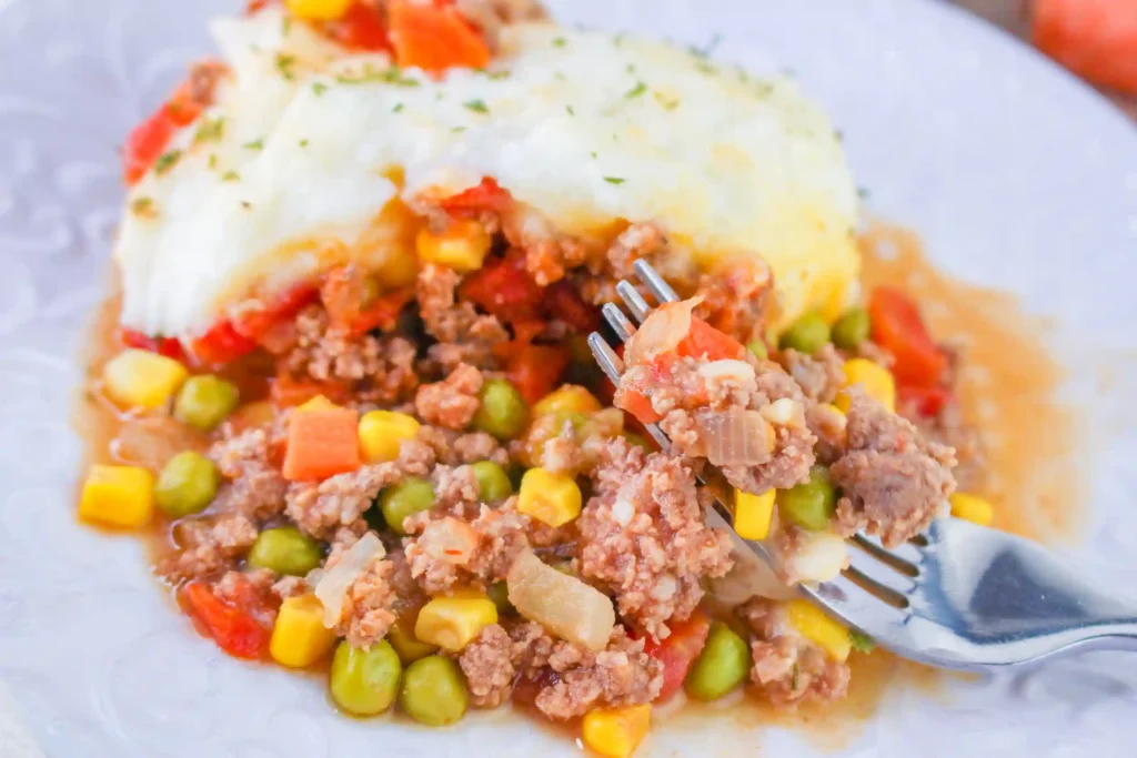 shepherd's pie on a white plate with a fork