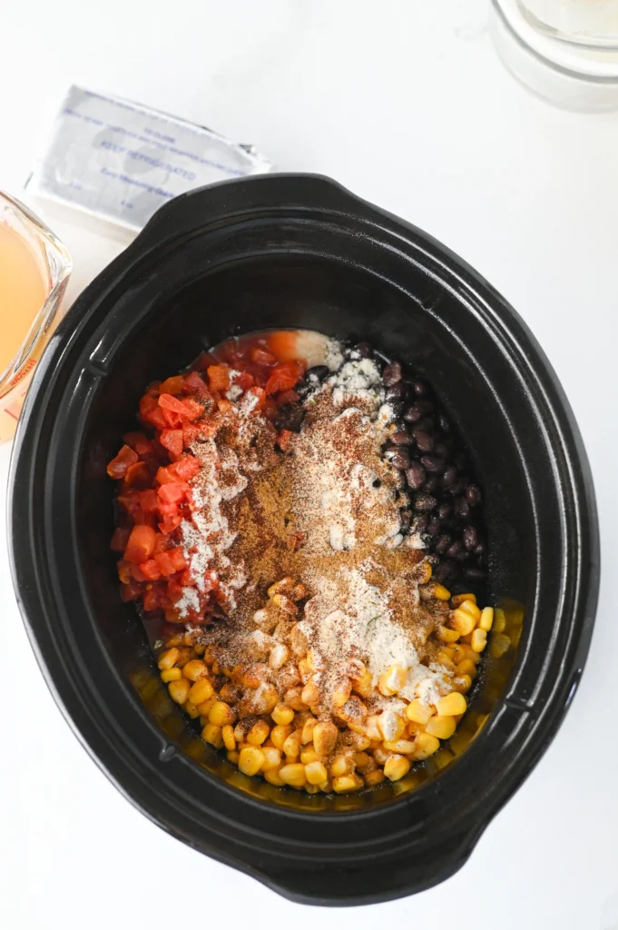 chicken, beans, tomatoes, spices and corn in a crockpot