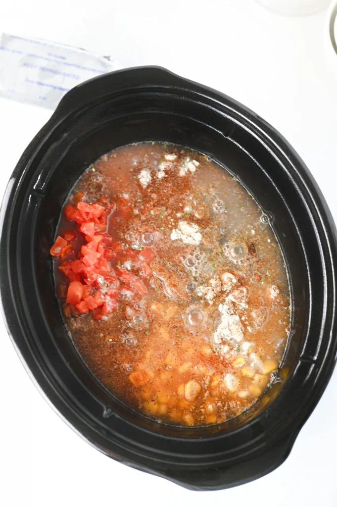 chicken, beans, tomatoes, spices and corn in a crockpot with chicken broth
